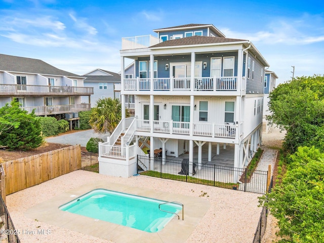 822 S Topsail Dr Unit B, Surf City, NC 28445 - rear view of house featuring a balcony, a patio area, a fenced backyard, and stairway
