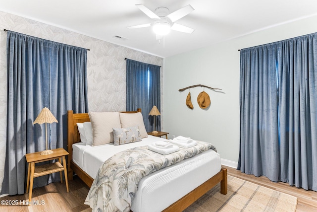 822 S Topsail Dr Unit B, Surf City, NC 28445 - bedroom featuring wallpapered walls, wood finished floors, baseboards, and ceiling fan