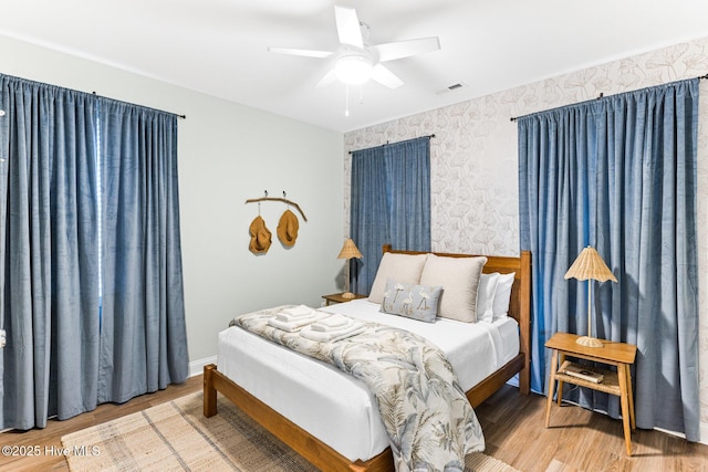 822 S Topsail Dr Unit B, Surf City, NC 28445 - bedroom featuring wood finished floors, wallpapered walls, and a ceiling fan