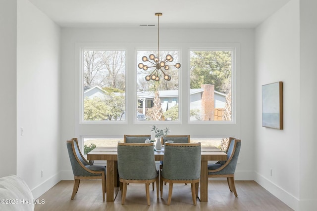 609 Augusta Ave, Carolina Beach, NC 28428 - dining area with a chandelier, baseboards, and light wood-type flooring