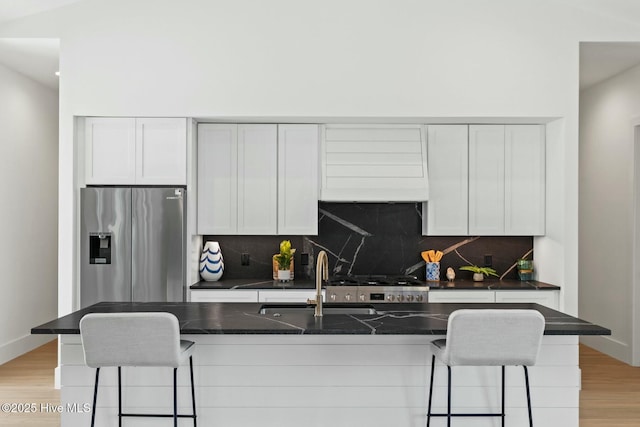 609 Augusta Ave, Carolina Beach, NC 28428 - kitchen with stainless steel appliances, a sink, custom exhaust hood, a breakfast bar, and tasteful backsplash