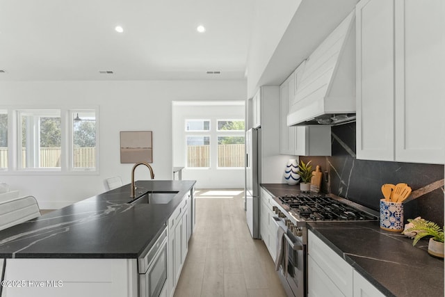 609 Augusta Ave, Carolina Beach, NC 28428 - kitchen with stainless steel appliances, a sink, custom range hood, dark countertops, and recessed lighting