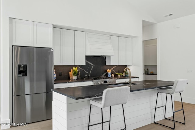609 Augusta Ave, Carolina Beach, NC 28428 - kitchen with stainless steel fridge, premium range hood, tasteful backsplash, range, and light wood-style floors