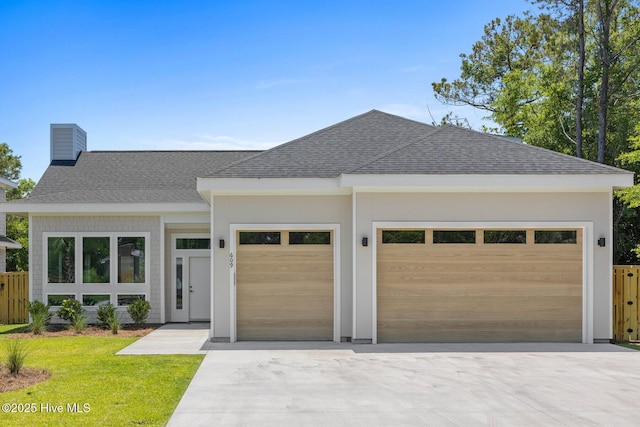 609 Augusta Ave, Carolina Beach, NC 28428 - view of front facade with a shingled roof, an attached garage, driveway, and a chimney