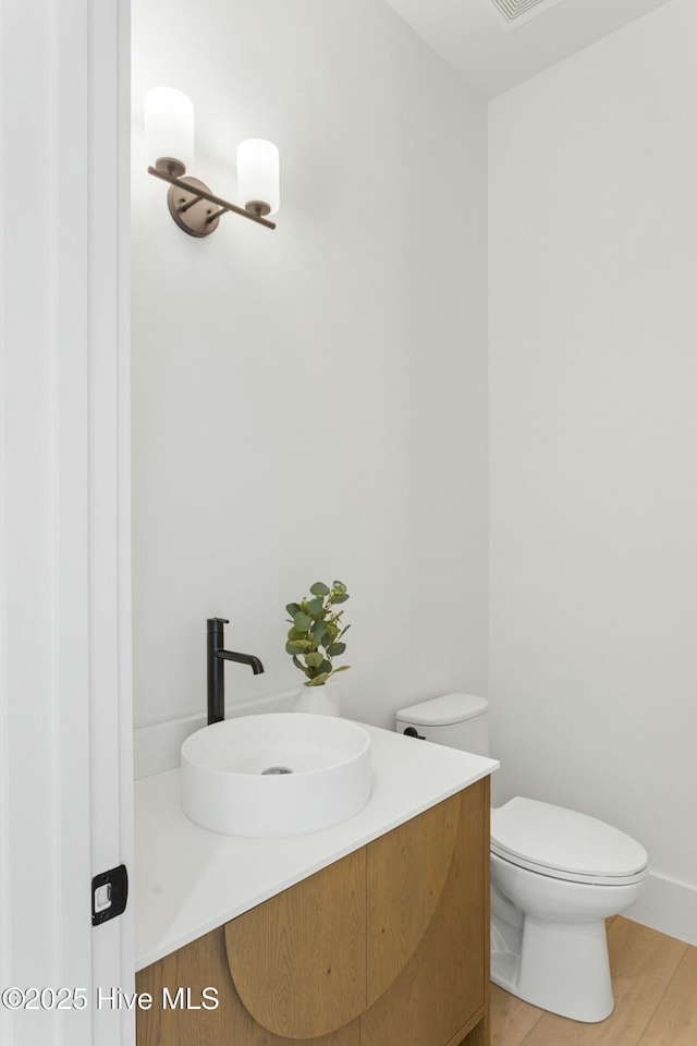 609 Augusta Ave, Carolina Beach, NC 28428 - half bathroom with vanity, toilet, and wood finished floors