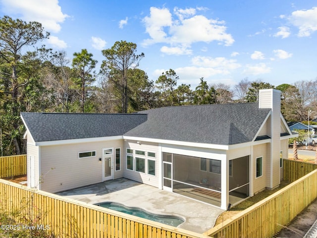 609 Augusta Ave, Carolina Beach, NC 28428 - back of property with a patio, a chimney, a fenced backyard, and a shingled roof