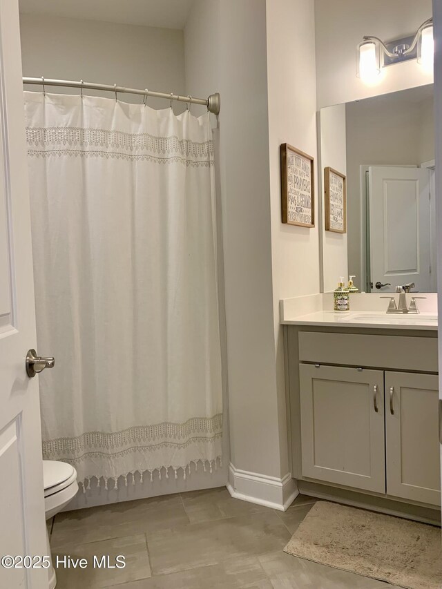 8941 Cobble Ridge Dr, Wilmington, NC 28411 - bathroom featuring vanity, toilet, baseboards, and a shower with curtain