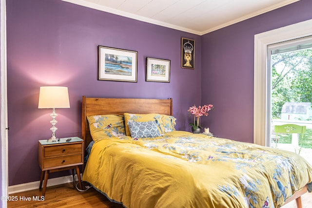 bedroom featuring wood finished floors, baseboards, and crown molding
