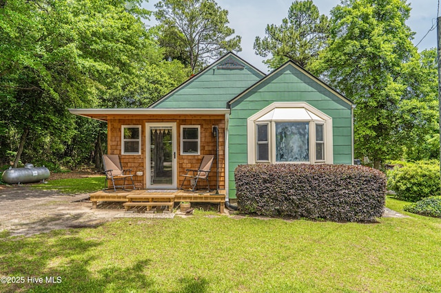 view of front of home featuring a front yard and a wooden deck
