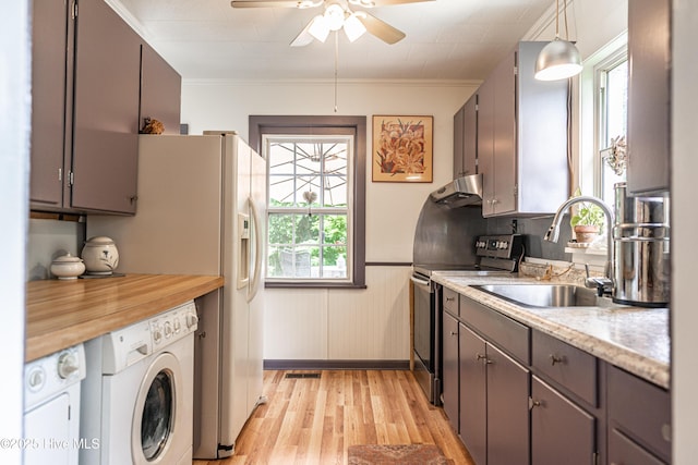 kitchen with stainless steel range with electric cooktop, washer / clothes dryer, under cabinet range hood, light wood-style floors, and a sink