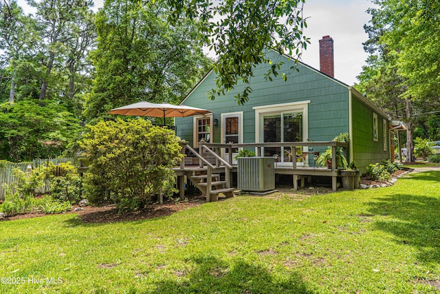 back of property with a chimney and a wooden deck