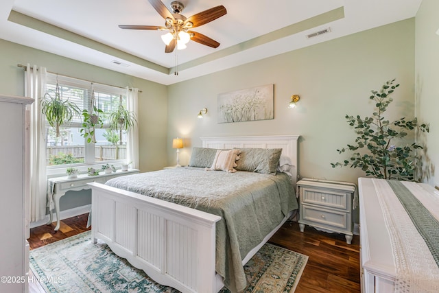104 NE 63rd St, Oak Island, NC 28465 - bedroom with a raised ceiling, dark wood-type flooring, and a ceiling fan