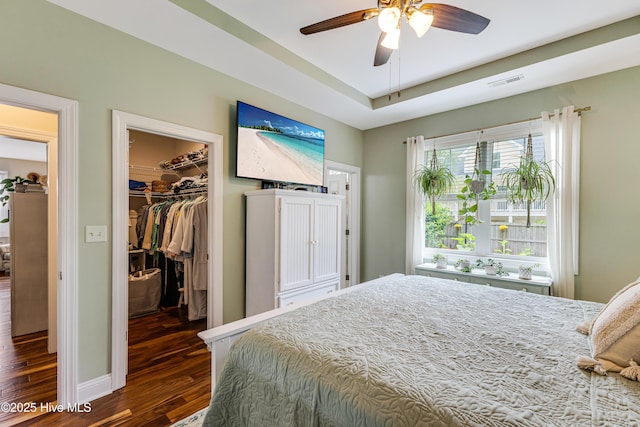 104 NE 63rd St, Oak Island, NC 28465 - bedroom featuring dark wood finished floors, a walk in closet, a closet, and ceiling fan