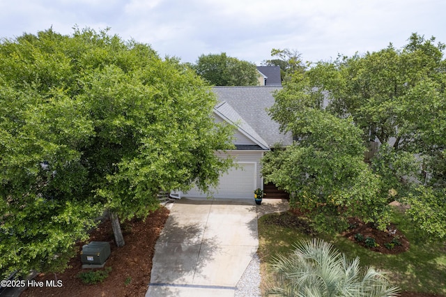 104 NE 63rd St, Oak Island, NC 28465 - obstructed view of property with concrete driveway and roof with shingles