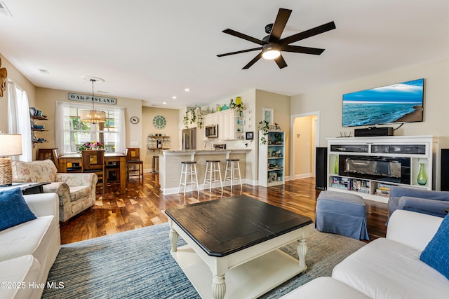 104 NE 63rd St, Oak Island, NC 28465 - living room featuring dark wood-style floors, ceiling fan, baseboards, recessed lighting, and a chandelier