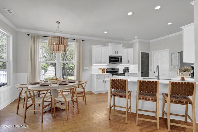 127 Azalea Dr, Hampstead, NC 28443 - kitchen featuring stainless steel appliances, a sink, plenty of natural light, light wood-style floors, and wainscoting