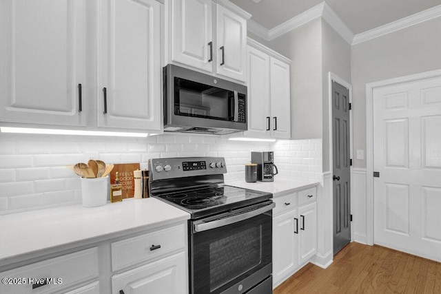 127 Azalea Dr, Hampstead, NC 28443 - kitchen featuring appliances with stainless steel finishes, crown molding, white cabinets, light wood-style flooring, and light countertops