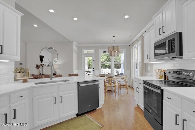 127 Azalea Dr, Hampstead, NC 28443 - kitchen featuring stainless steel appliances, a sink, a peninsula, a chandelier, and light wood finished floors