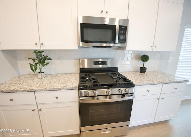 9308 Little Osprey Dr, Calabash, NC 28467 - kitchen featuring stainless steel appliances, white cabinetry, and decorative backsplash