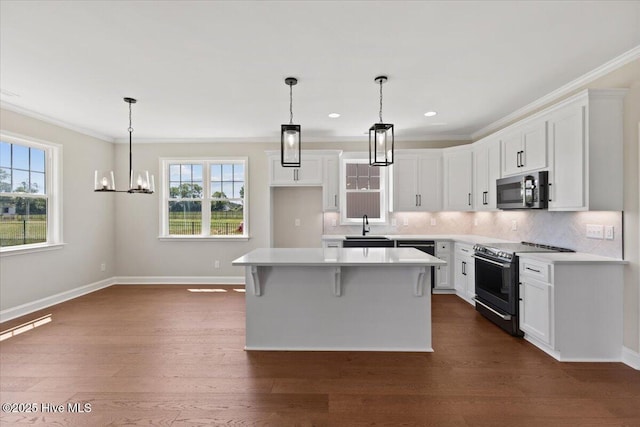 2190 Heartland Rd, Battleboro, NC 27809 - kitchen with electric range oven, stainless steel microwave, a sink, plenty of natural light, and ornamental molding