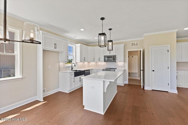 2190 Heartland Rd, Battleboro, NC 27809 - kitchen featuring stainless steel appliances, dark wood-style flooring, light countertops, white cabinetry, and ornamental molding