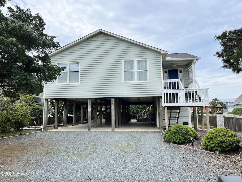315 Brunswick Ave W, Holden Beach, NC 28462 - coastal home featuring a carport, stairway, driveway, ceiling fan, and a shingled roof