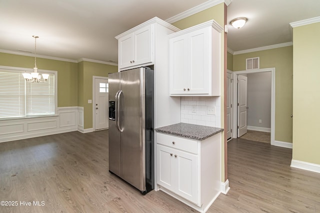 1707 N Carolina St, Goldsboro, NC 27530 - kitchen with stainless steel fridge, a chandelier, light wood-style flooring, white cabinetry, and crown molding