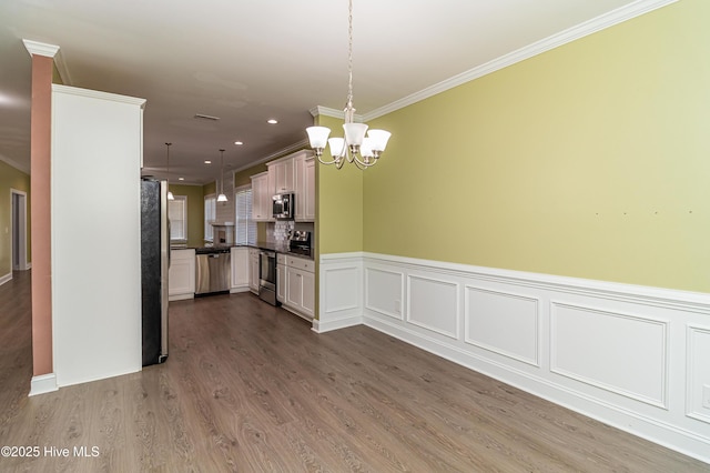 1707 N Carolina St, Goldsboro, NC 27530 - kitchen with stainless steel appliances, crown molding, dark countertops, a chandelier, and hanging light fixtures