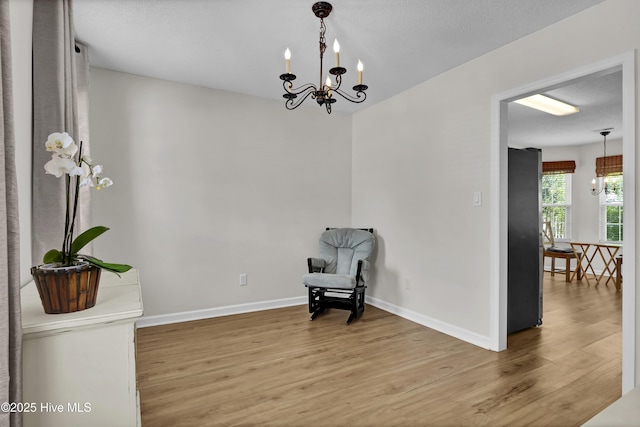 5109 Gate Post Ln, Wilmington, NC 28412 - unfurnished room featuring wood finished floors, a chandelier, baseboards, and a textured ceiling