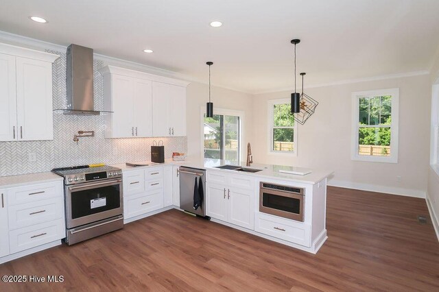 472 Yadkin Rd, Southern Pines, NC 28387 - kitchen with appliances with stainless steel finishes, wall chimney range hood, a sink, a peninsula, and crown molding