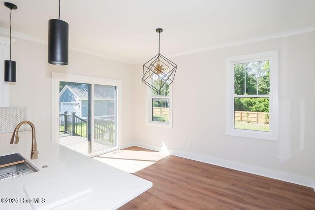 472 Yadkin Rd, Southern Pines, NC 28387 - unfurnished dining area with wood finished floors, healthy amount of natural light, ornamental molding, a sink, and baseboards