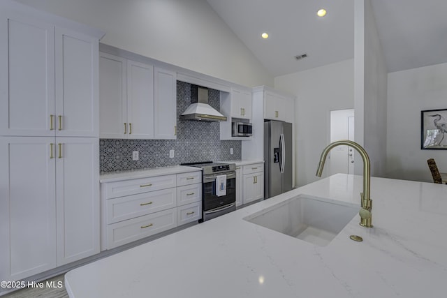 302 Gaskins Ln, Wilmington, NC 28411 - kitchen featuring wall chimney exhaust hood, stainless steel appliances, a sink, vaulted ceiling, and decorative backsplash