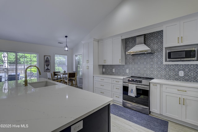302 Gaskins Ln, Wilmington, NC 28411 - kitchen with appliances with stainless steel finishes, wall chimney exhaust hood, a sink, vaulted ceiling, and white cabinetry