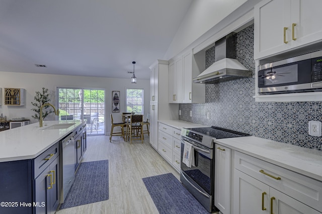 302 Gaskins Ln, Wilmington, NC 28411 - kitchen with a sink, appliances with stainless steel finishes, wall chimney range hood, white cabinetry, and backsplash