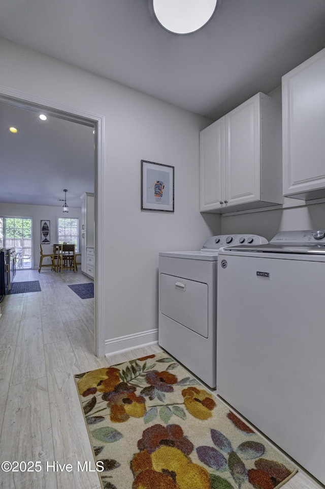 302 Gaskins Ln, Wilmington, NC 28411 - laundry room featuring washer and clothes dryer, cabinet space, light wood-style flooring, and baseboards