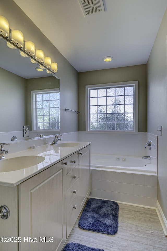 302 Gaskins Ln, Wilmington, NC 28411 - bathroom with wood finished floors, a garden tub, and double vanity