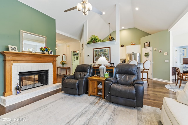 308 Crooked Gulley Cir, Sunset Beach, NC 28468 - living area featuring a ceiling fan, wood finished floors, a brick fireplace, baseboards, and high vaulted ceiling