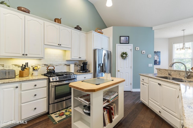 308 Crooked Gulley Cir, Sunset Beach, NC 28468 - kitchen featuring appliances with stainless steel finishes, a sink, white cabinetry, tasteful backsplash, and vaulted ceiling