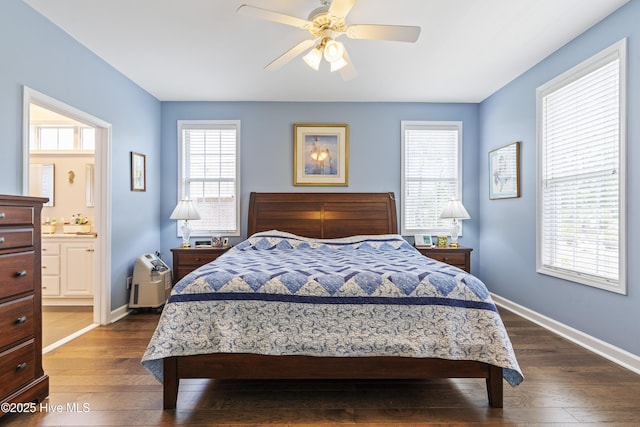 308 Crooked Gulley Cir, Sunset Beach, NC 28468 - bedroom featuring dark wood-style flooring, baseboards, ensuite bath, and a ceiling fan