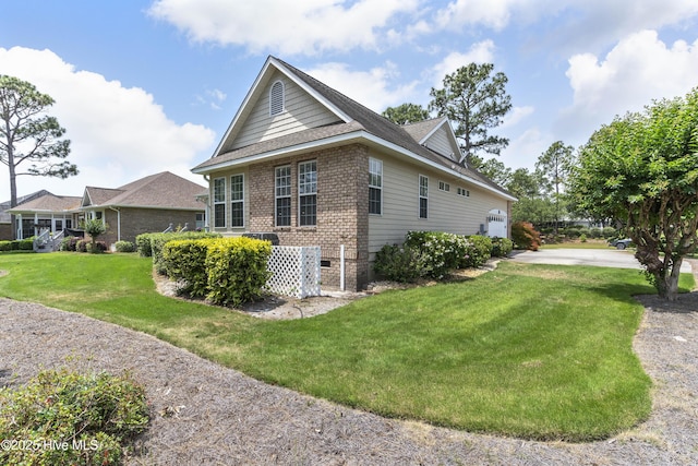 308 Crooked Gulley Cir, Sunset Beach, NC 28468 - view of home's exterior featuring a garage, brick siding, a lawn, and driveway