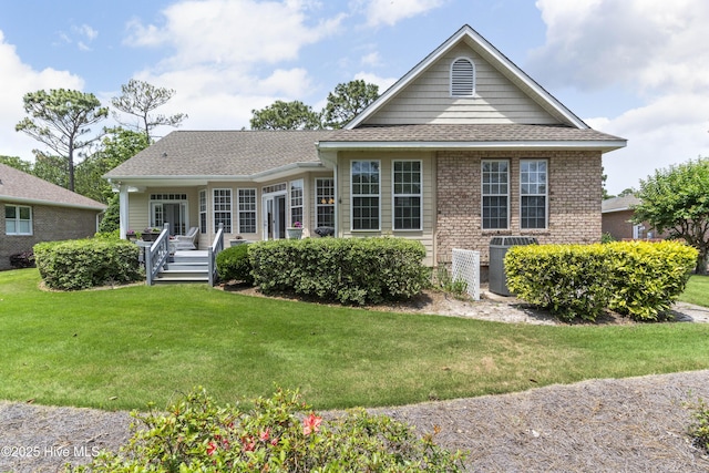 308 Crooked Gulley Cir, Sunset Beach, NC 28468 - view of front of property featuring central air condition unit, a front yard, roof with shingles, and covered porch