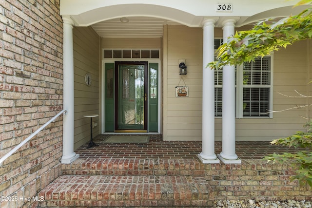 308 Crooked Gulley Cir, Sunset Beach, NC 28468 - doorway to property featuring covered porch and brick siding