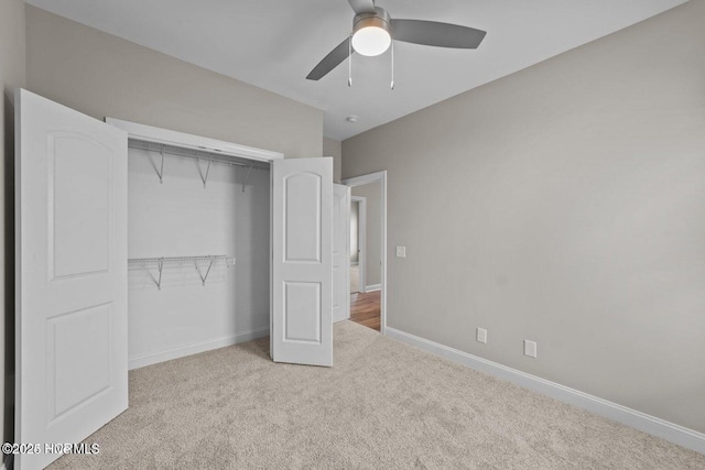 unfurnished bedroom with carpet floors, a closet, baseboards, and ceiling fan