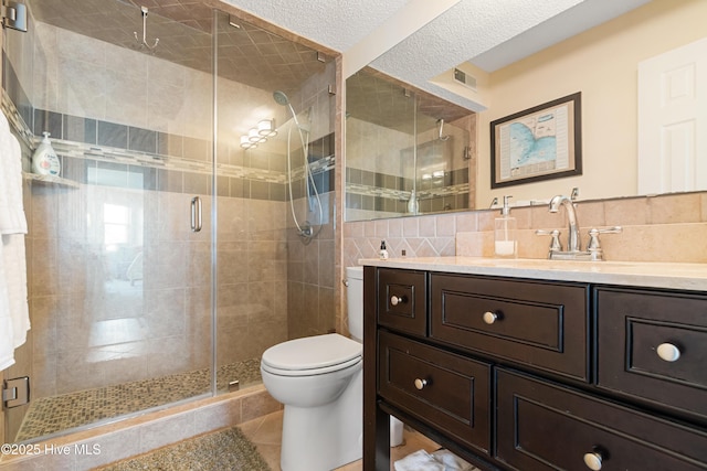 2000 New River Inlet Rd Unit 3113, North Topsail Beach, NC 28460 - bathroom with vanity, toilet, a stall shower, tile patterned flooring, and backsplash