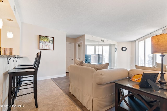 2000 New River Inlet Rd Unit 3113, North Topsail Beach, NC 28460 - living room with a textured ceiling, tile patterned flooring, and baseboards