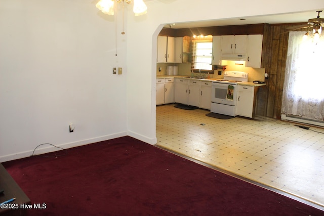2489 Rodgers School Rd, Williamston, NC 27892 - kitchen featuring white range with electric stovetop, ceiling fan, baseboards, arched walkways, and light countertops