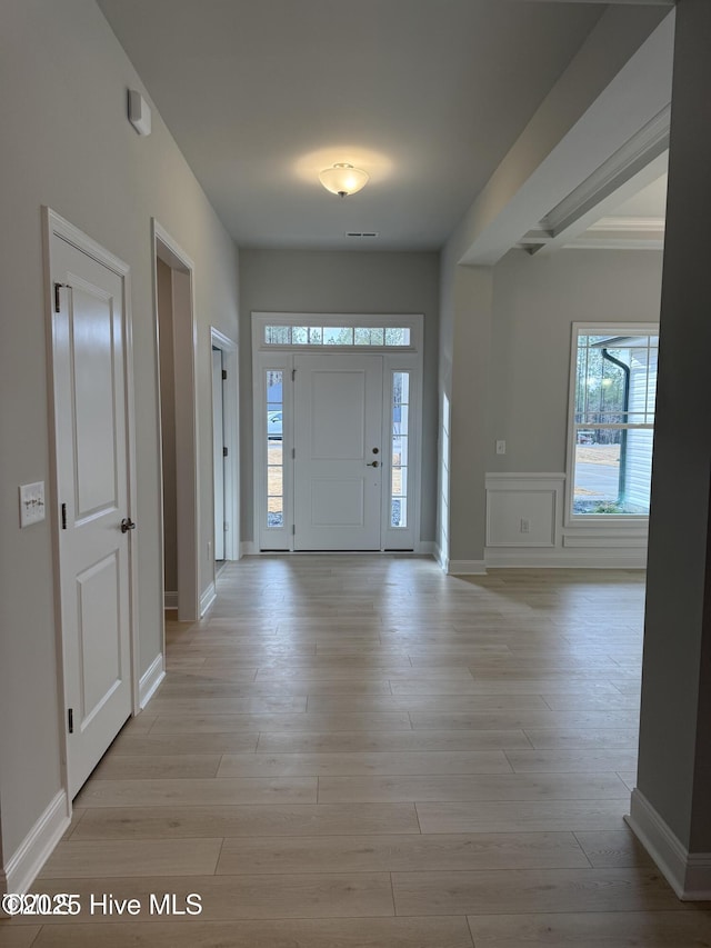 entrance foyer with healthy amount of natural light, light wood-style floors, and baseboards