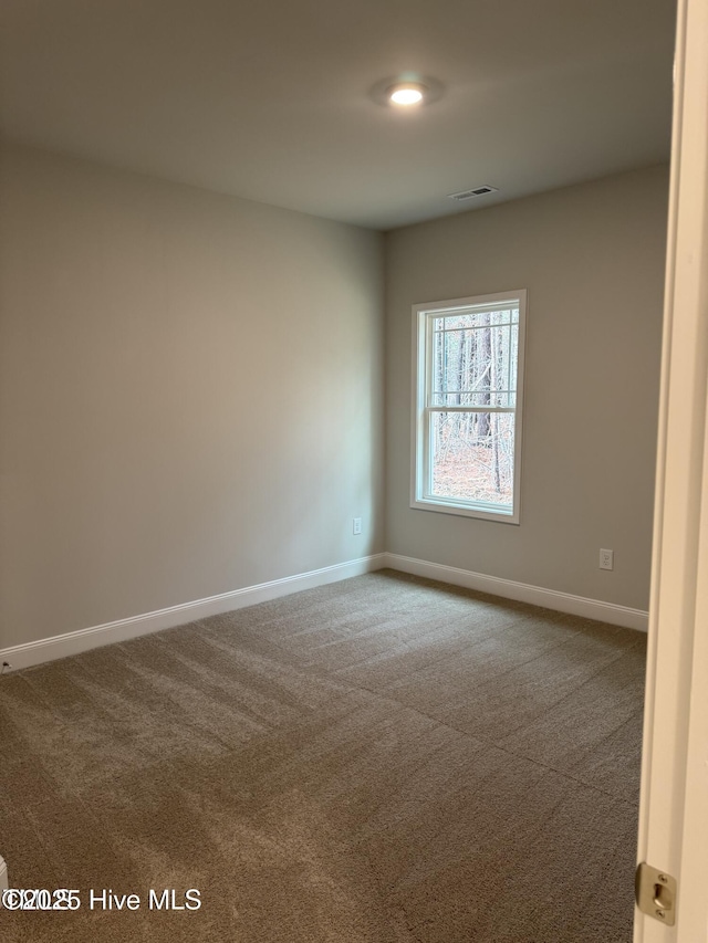 unfurnished room featuring dark carpet and baseboards