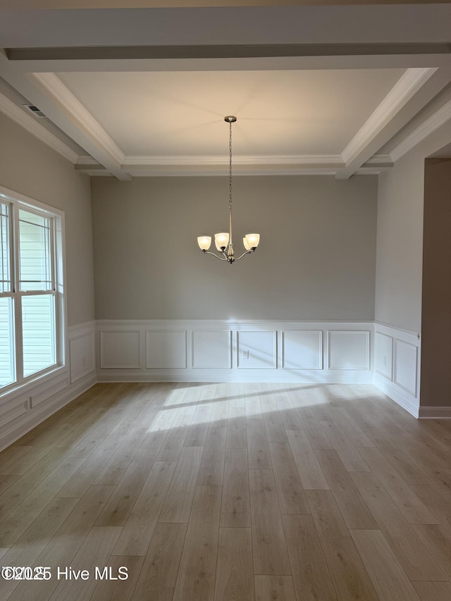 unfurnished dining area featuring ornamental molding, a chandelier, wood finished floors, beamed ceiling, and a decorative wall