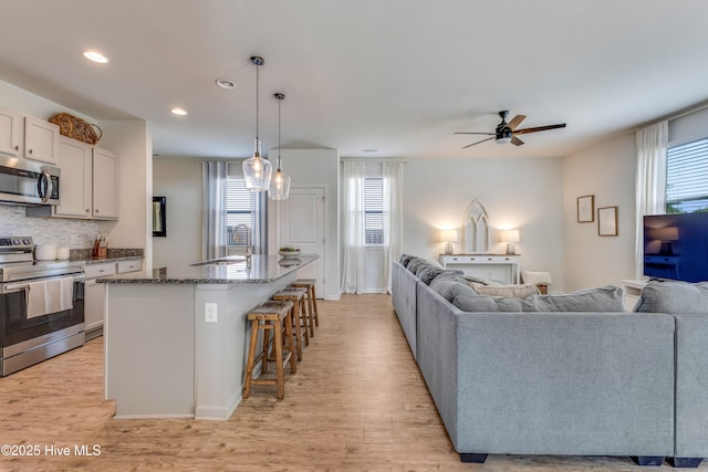815 Avington Ln NE, Leland, NC 28451 - kitchen with stainless steel appliances, open floor plan, a ceiling fan, light wood-style flooring, and recessed lighting